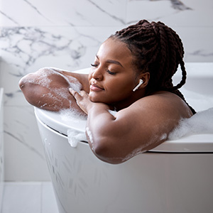 Person relaxing in bathtub with bubbles