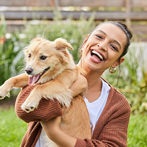 Person holding dog in outdoor setting